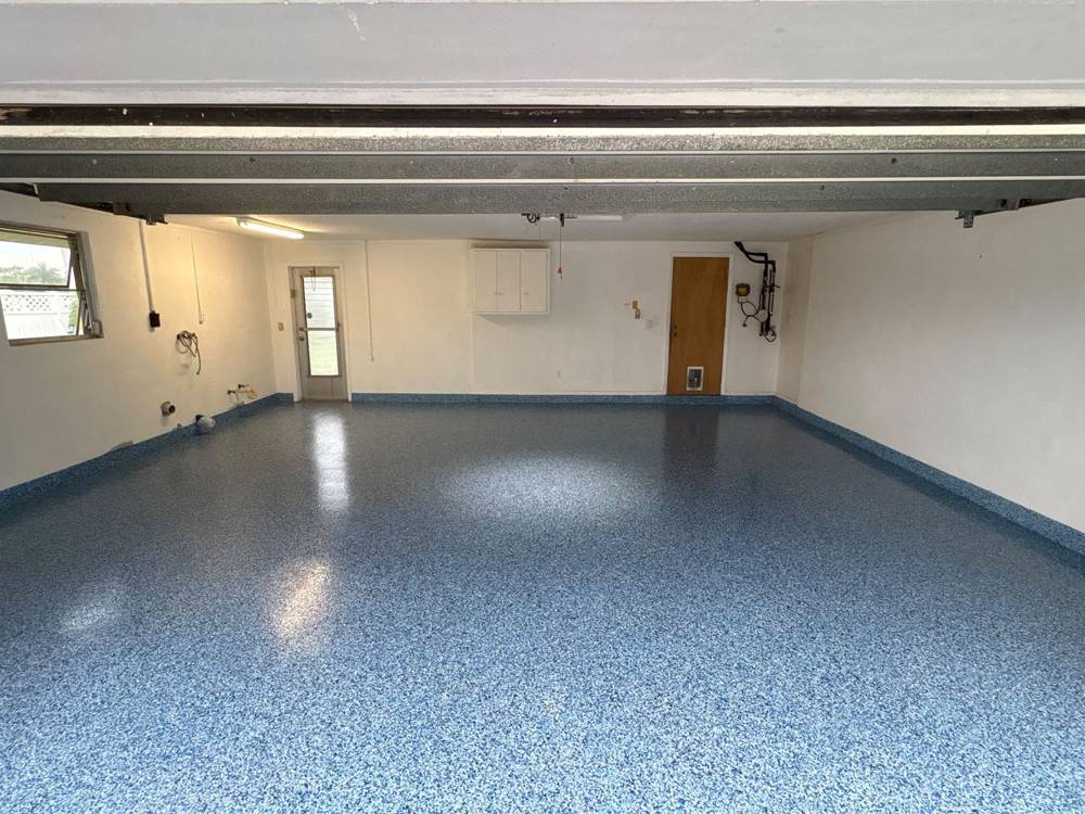 Garage floor with blue epoxy flake finish and cove base